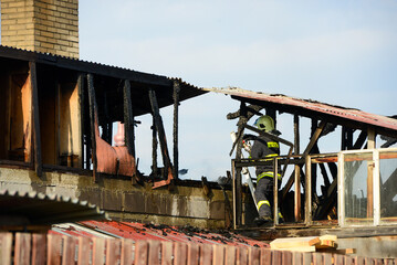 Strong and brave firefighters on burning house are trying to extinguish open fire. Liptovsky Mikulas, Slovakia.