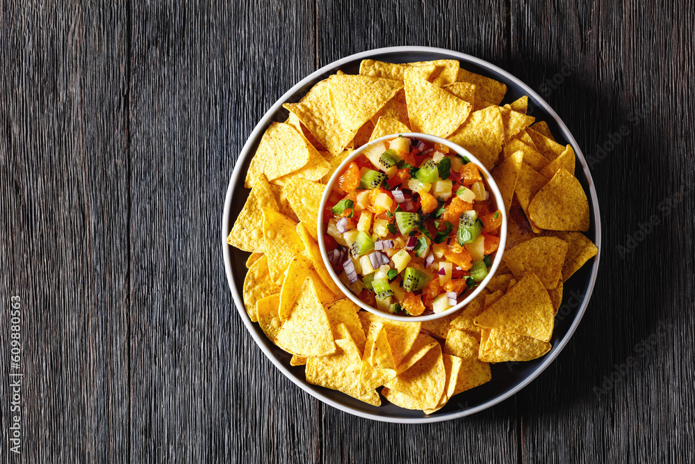 Sticker summer fruit salsa with tortilla chips on plate