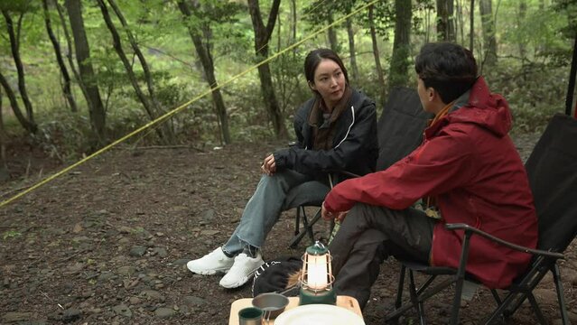 조용한 숲속에서 마주보며 이야기를 나누며 휴식하는 부부 