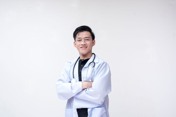 Portrait of a young and professional doctor, medical student, intern, posing looking happy with his arms crossed and folded. Isolated on a white background.