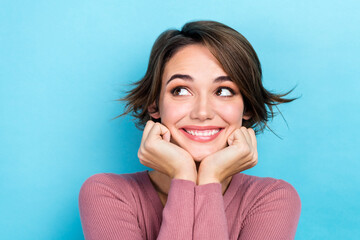 Photo of thoughtful dreamy lady wear pink cardigan arms cheeks looking empty space isolated blue color background