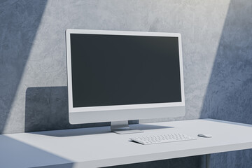 Close up of empty mock up computer screen on desktop and concrete wall background with shadow. Designer desktop and ad concept. 3D Rendering.