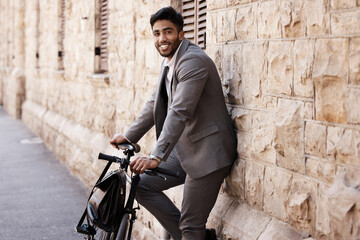 Fototapeta na wymiar Bicycle, portrait and happy business man in city for carbon neutral, sustainable and transport. Bike, commute and Indian male person on cycling break, smile and relax while traveling in India