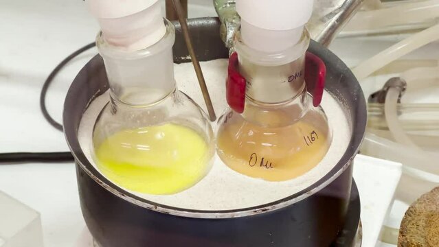 Colourful reactions under heating condition in sand bath. 4K video experiments in a chemistry lab. Biochemical medicine synthesis in the laboratory.