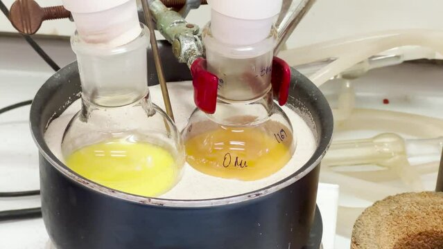 Colourful reactions under heating condition in sand bath. 4K video experiments in a chemistry lab. Biochemical medicine synthesis in the laboratory.