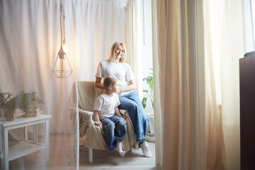 Happy loving family with mother and daughter in living room. Woman mom and small child girl playing and having convercation inside of the home