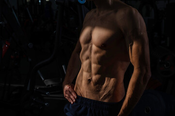 Obraz na płótnie Canvas Shirtless man with sculpted body in the gym. 