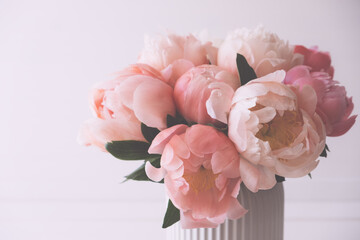 Beautiful bouquet of fresh coral peony flowers in full bloom in vase. Floral still life with blooming peonies. © Iryna