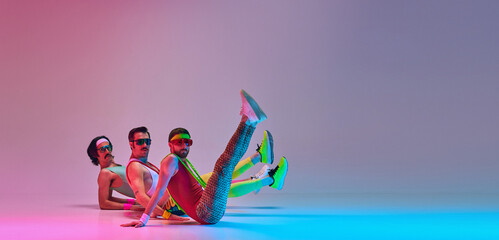 Men in colorful retro sportswear doing aerobics exercises on gradient blue pink studio background....