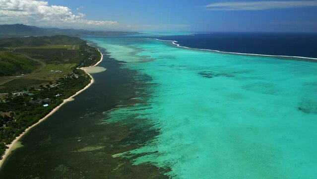 Slow aerial pan of Po&eacute; Beach, Domaine de Deva lagoon in Grand Terre, New Caledonia.