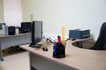 An office without people with desks with computers and a printer