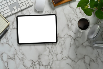 Flat lay, top view of digital tablet with empty dimply, coffee cup, notebook and potted plant on marble table