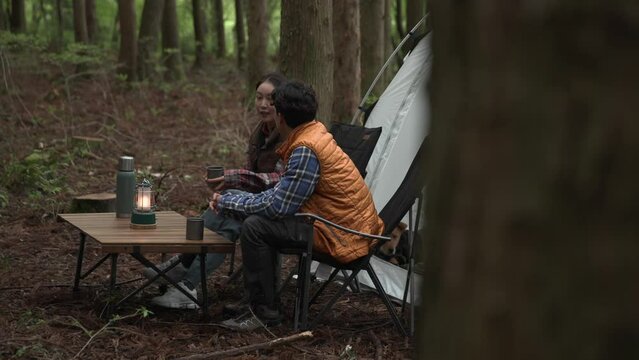 조용한 숲속에서 마주보며 이야기를 나누며 휴식하는 부부