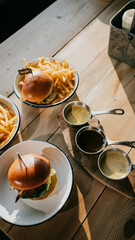 A table topped with plates of burger and Chips.