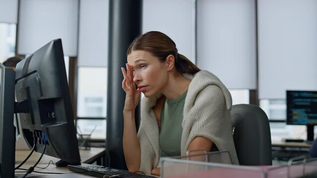 Tired employee working computer in office. Overwhelmed woman analyzing sales
