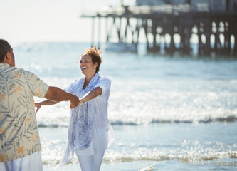 Enthusiastic couple dancing on sunny beach
