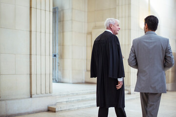 Judge and lawyer walking through courthouse together 