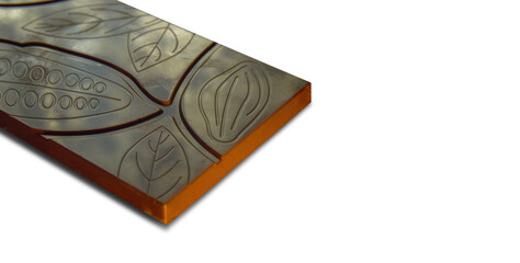a piece of chocolate bar with leaf patterns and scuffs on a white isolated background