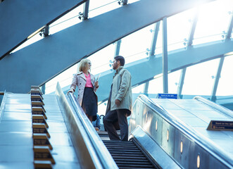 Business people riding escalator
