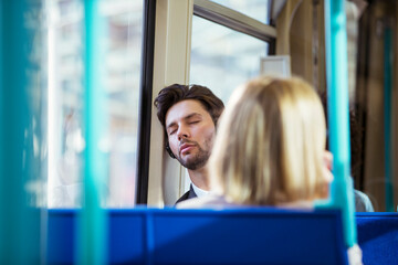 Businessman napping on train