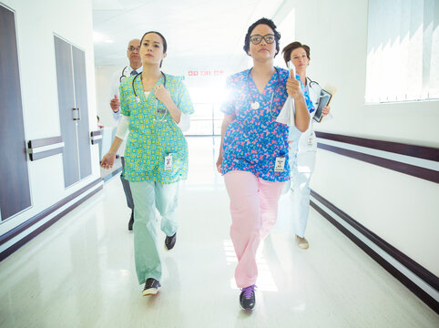 Doctors And Nurses Running Down Hospital Corridor