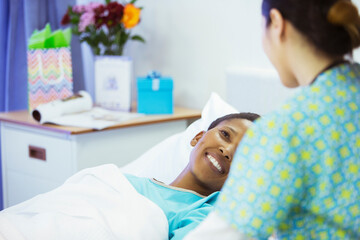 Smiling patient in hospital bed smiling at nurse