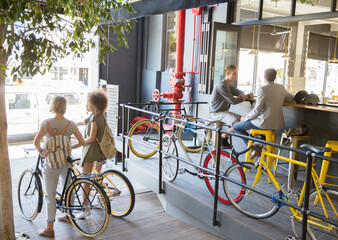 People with bicycles at urban outdoor cafe