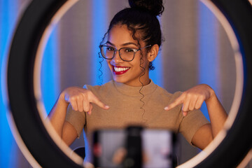 Influencer woman, ring light and portrait with smile, pointing and beauty on live stream, broadcast...