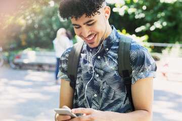Smiling man curly black hair listening to music headphones mp3 player