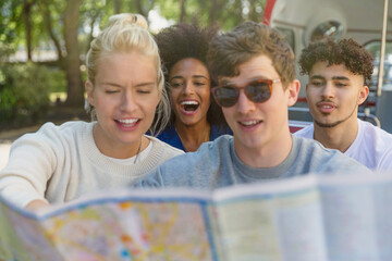 Friends looking at map on double-decker bus