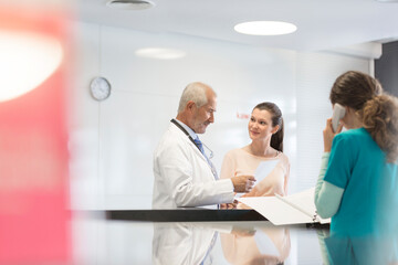 Fototapeta premium Doctor and patient discussing medical record at nurses station