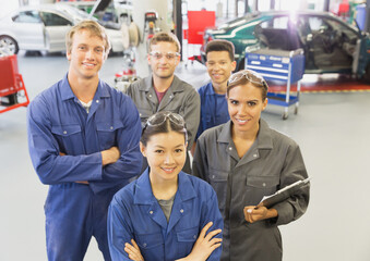 Portrait confident mechanics in auto repair shop - obrazy, fototapety, plakaty