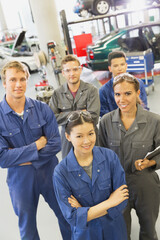 Portrait smiling mechanics in auto repair shop