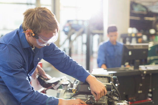 Mechanic working on engine in auto repair shop