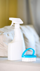 Bottle with cleaning agent and brush on the background of the room. Image with selective focus
