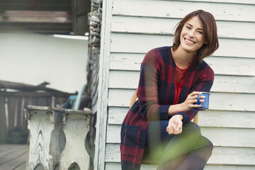 Portrait smiling brunette woman drinking coffee on porch