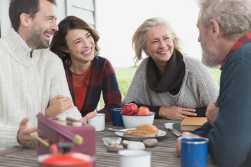 Couples talking and enjoying breakfast at patio table