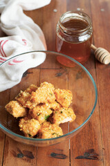 Crispy salmon bites with spicy mayo sauce, baked. White and wooden background