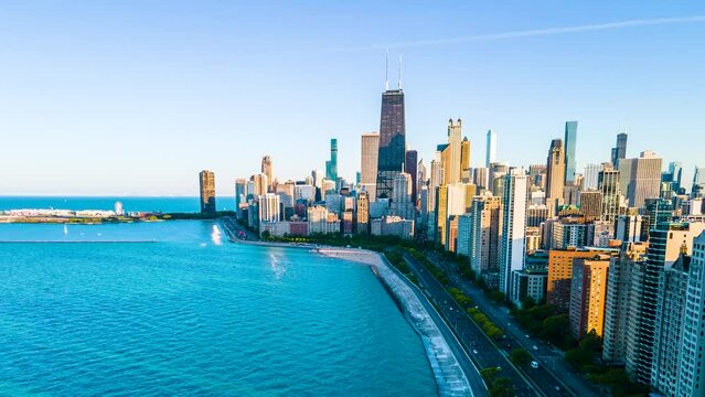 Aerial hyper lapse footage of Chicago lake front during late evening. Cars and pedestrians speed by as the sun slowly sets in the back ground. the beautiful skyscraper showcases the city architecture.
