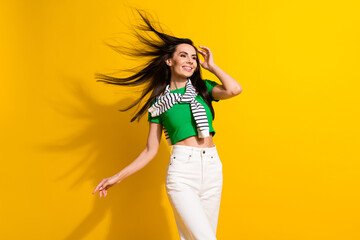 Photo of stunning lovely positive fashionista lady flying hair new outfit collection empty space ad isolated on yellow color background