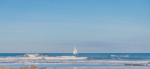 Panoramic view of sea (ocean) surf skyline with a sail, minimalistic style, copy space, panorama