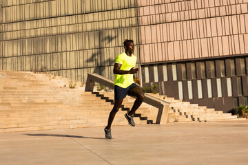 Fitness training outdoors. Handsome African man running. Muscular man training..