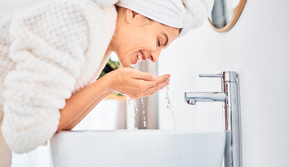 Water splash, skincare and happy woman washing her face in a bathroom for beauty, hygiene and...