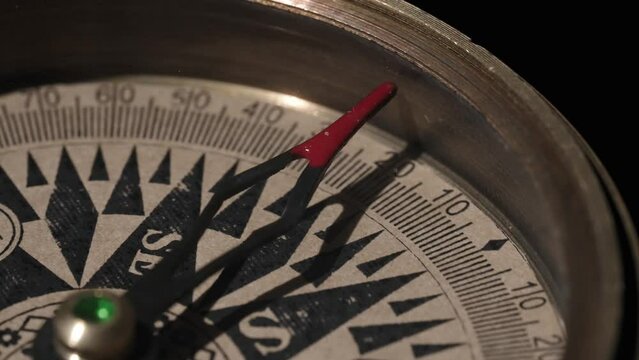 Rotating vintage compass close up on a black background. Concept of travel, adventure, expedition, business, choice and opportunity.