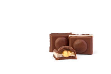 Three pieces of milk chocolate with toffee and whole nut on a white background.