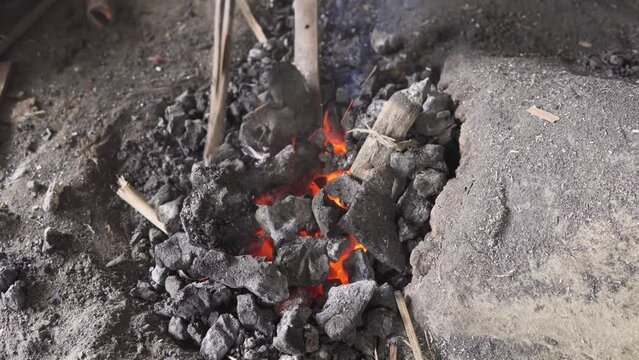 Charcoal heating of cocunut knife for bending by indian blacksmith