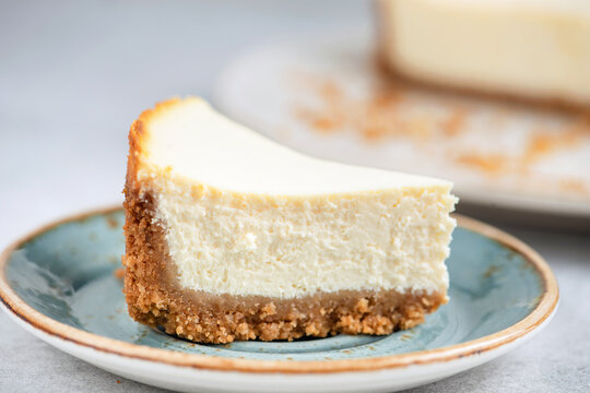 Classic cheesecake slice cut on a plate, closeup view. Bright and vibrant food photo of a popular dessert