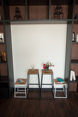 Shabby wooden table with chairs and vase located near comfortable couch against light walls with decorations in modern apartment. High quality photo