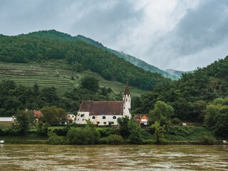Fototapeta na wymiar Church on the banks of the Danube in the Wachau Valley, Austria. Beautiful church on the river
