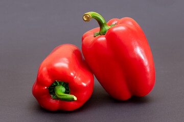 Two Fresh Red Sweet Bell Peppers on Black Background